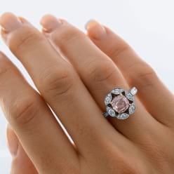 Вид золотого кольца с розовым бриллиантом на пальце